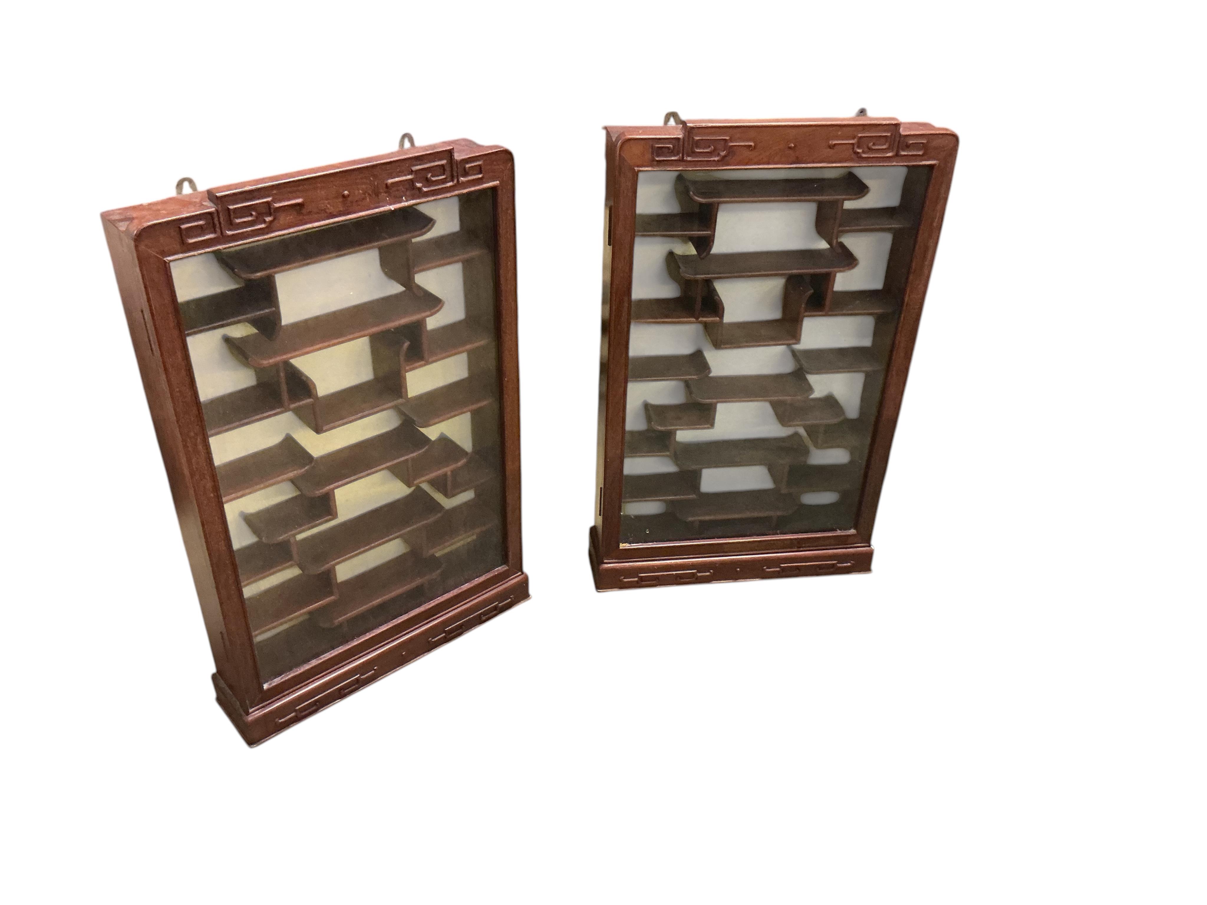 A pair of Chinese carved hardwood wall display cabinets, width 43cm, depth 10cm, height 71cm